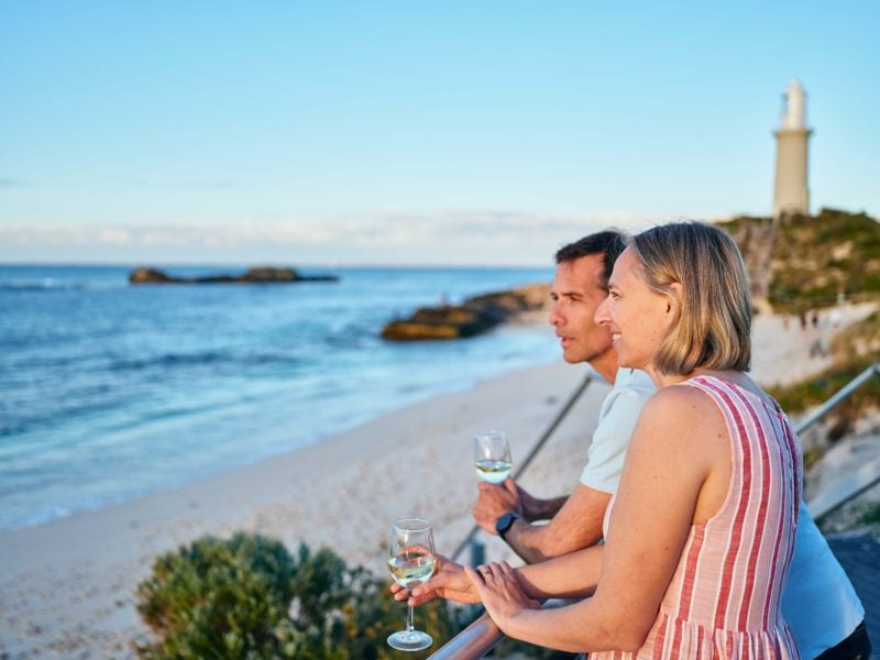 Couple having a sunset drink looking out over the beach and the lighthouse.