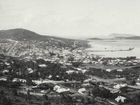 a black and white archival image of a landscape with a hill and urban sprawl