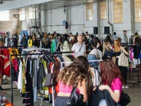 pictured is a view of the market with lots of racks of clothes and people