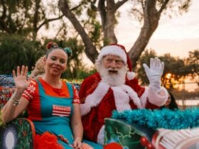 Santa and his elf waving to the crowds at the Christmas Pageant
