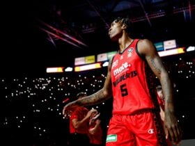 Wildcats player Kristian Doolittle walks into RAC Arena in the darkness lit up by torches