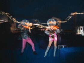 Two dancers in disco ball heads dancing on the roof