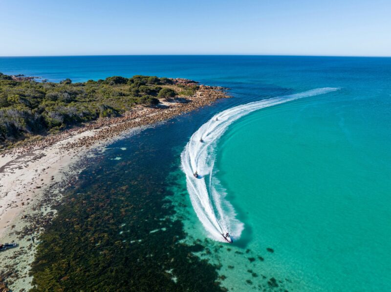 Jetskis cutting through the crystal-clear water, leaving a trail of white foam behind