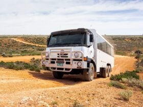 6WD coach tour vehicle driving on dirt road